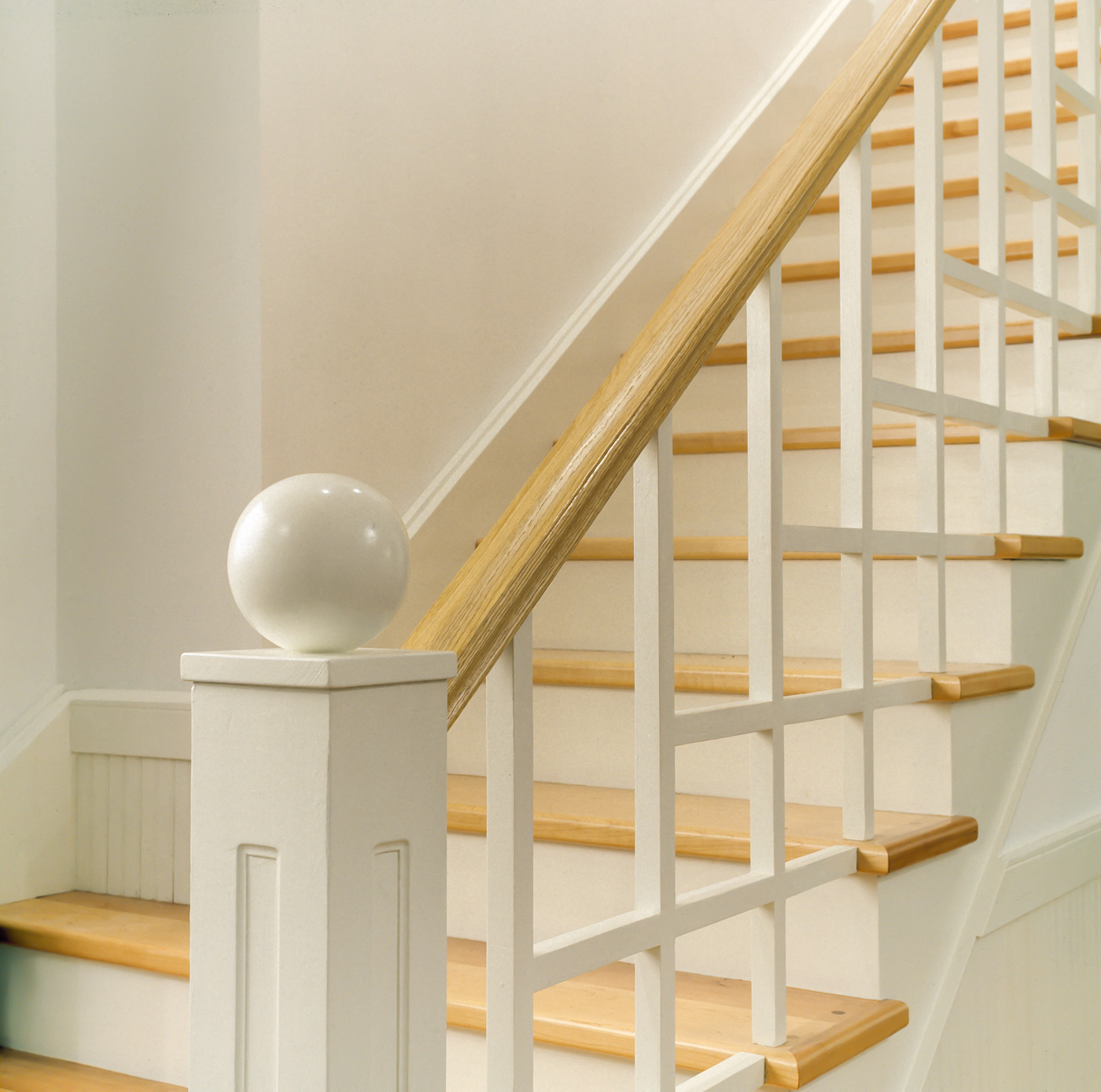 Details of a wooden stairset's handrail.