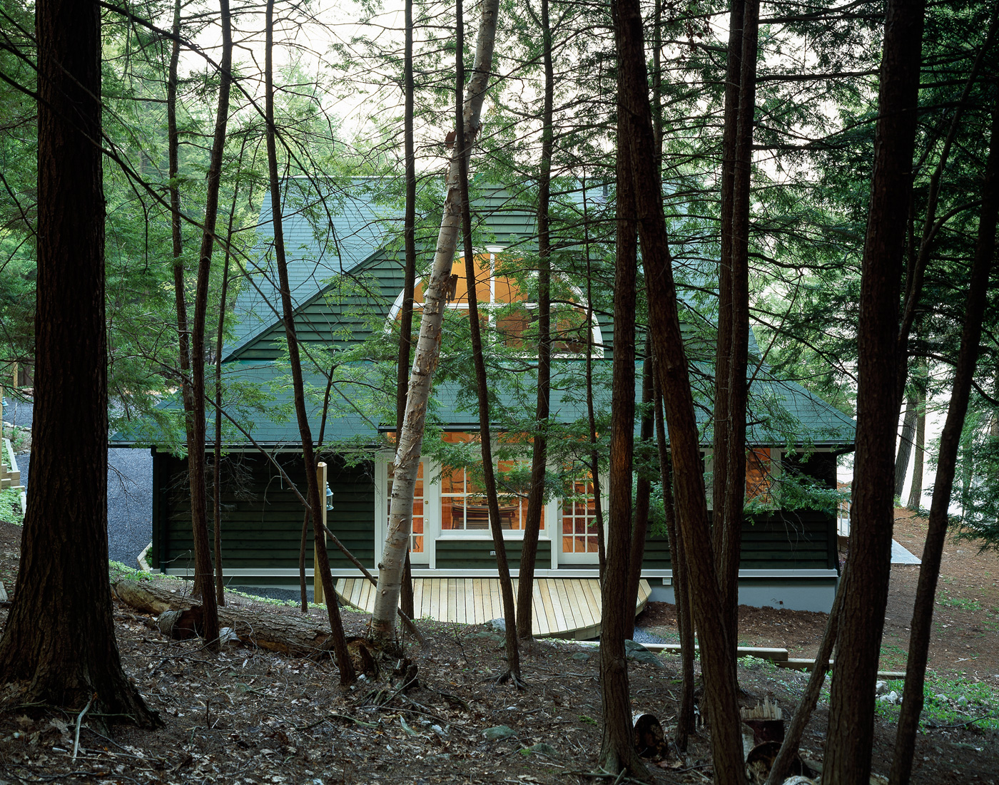 A cottage visible through surrounding. trees