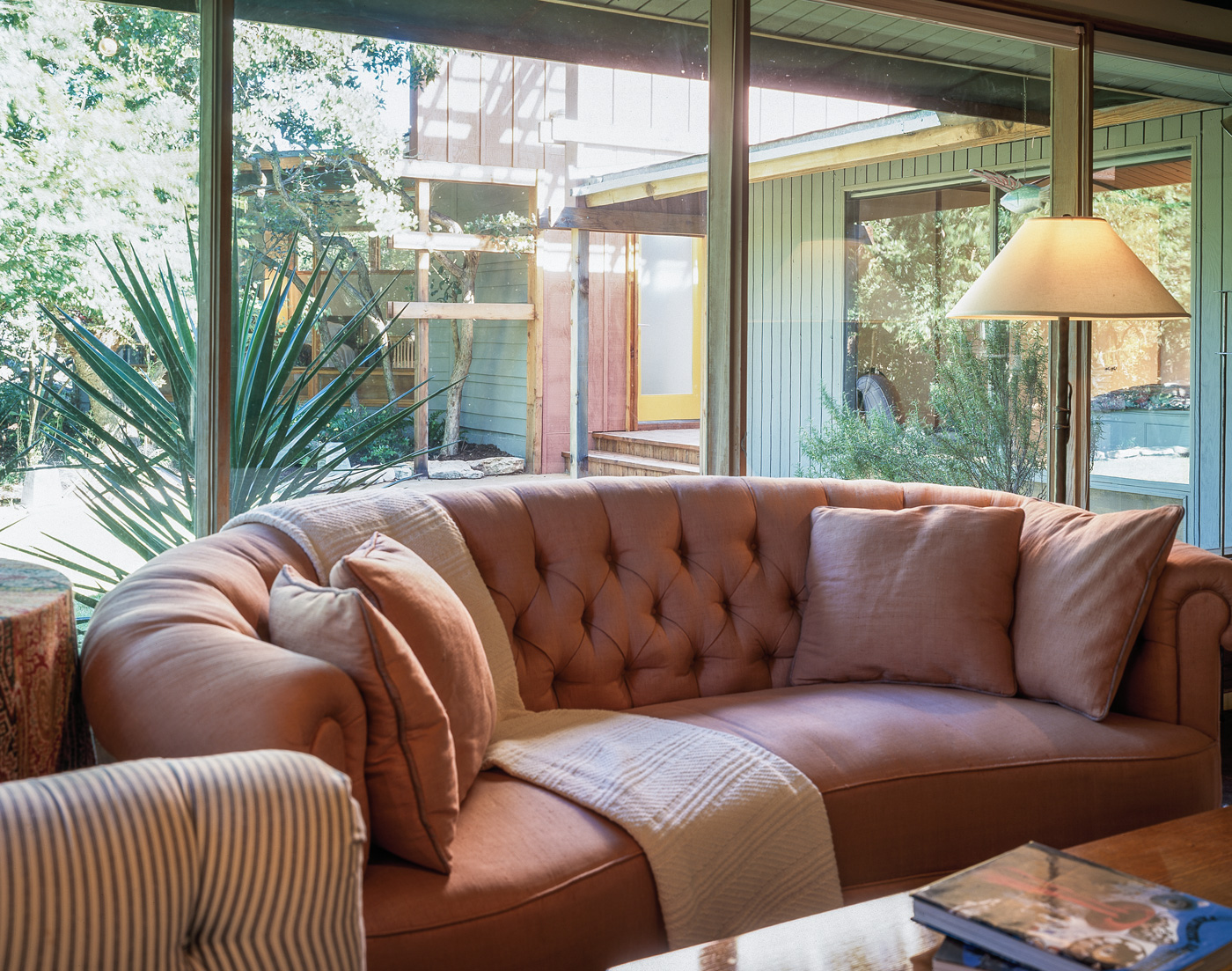 Livingroom couch against large backyard facing windows.