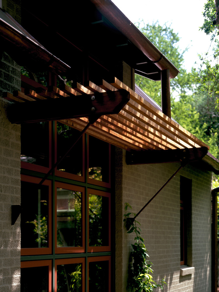 A wooden awning connected to side of a house.