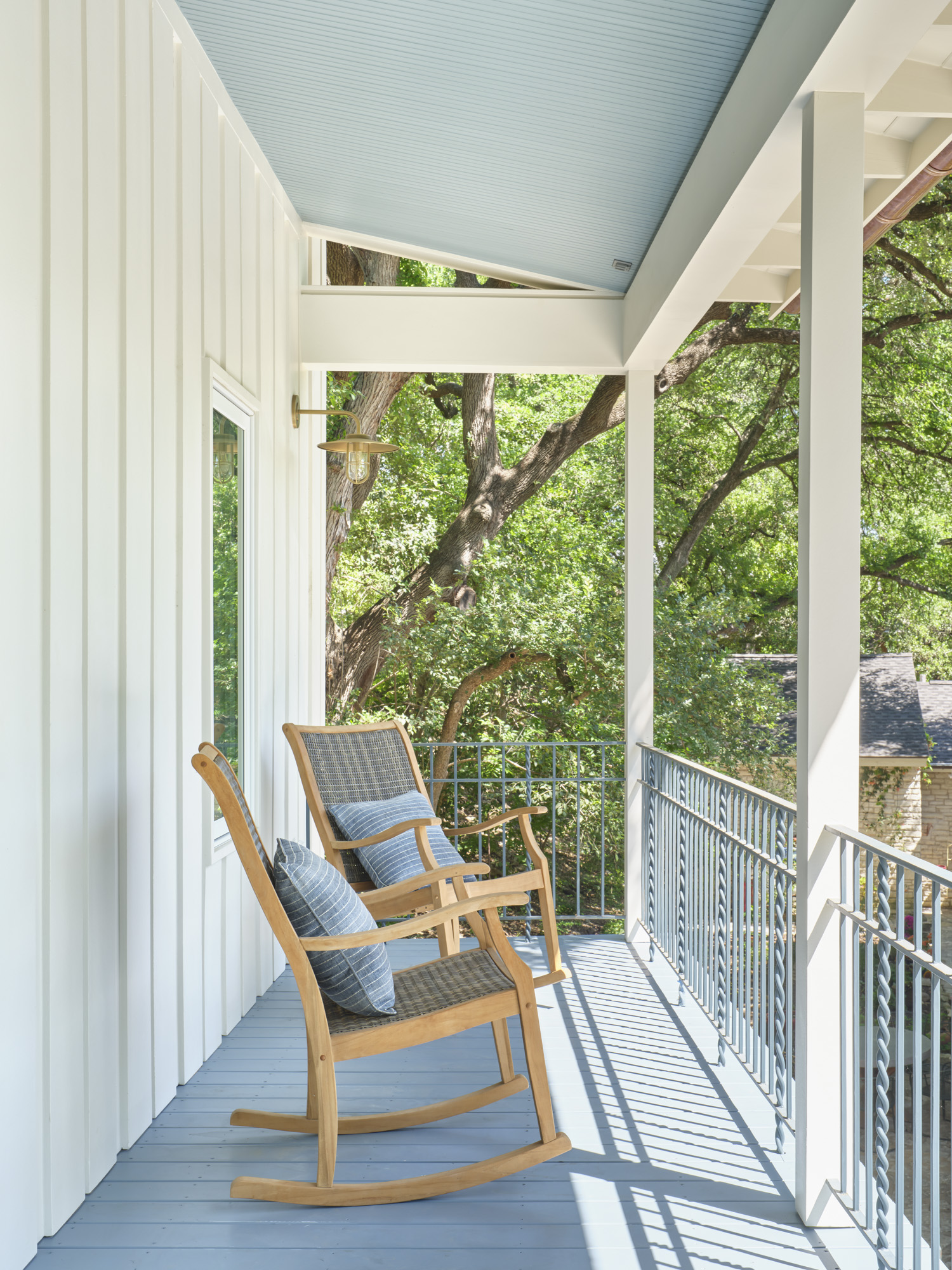 Two rocking chairs on a balcony.